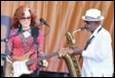 A person playing a saxophone next to a person playing a guitar

Description automatically generated with low confidence