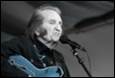 A person with a guitar in front of a microphone

Description automatically generated with medium confidence
