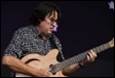 A person playing a guitar

Description automatically generated