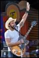 A person with a guitar and a microphone

Description automatically generated with low confidence