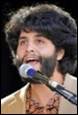 A person with a beard singing into a microphone

Description automatically generated with medium confidence