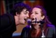 A person and person singing into a microphone

Description automatically generated