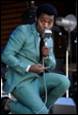 A person in a suit holding a microphone

Description automatically generated