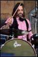 A person playing drums with a microphone

Description automatically generated with low confidence
