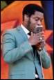 A person in a suit holding a microphone

Description automatically generated with medium confidence
