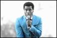 A person in a suit holding a microphone

Description automatically generated