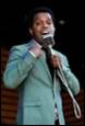 A person in a suit holding a microphone

Description automatically generated with medium confidence