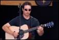 A person playing a guitar

Description automatically generated