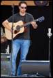 A person playing guitar on stage

Description automatically generated