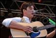 A person playing guitar and singing

Description automatically generated
