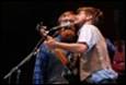 A person kissing another person with a guitar

Description automatically generated
