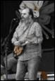 A person with a beard playing a guitar

Description automatically generated