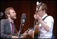 A group of men playing guitars and singing

Description automatically generated