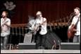 A person playing a guitar on stage

Description automatically generated