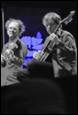A couple of men playing instruments

Description automatically generated