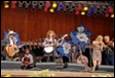 A group of people playing instruments on a stage

Description automatically generated