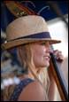 A person wearing a hat and holding a violin

Description automatically generated