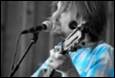A person with a microphone and a guitar

Description automatically generated