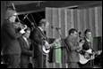 A group of men playing instruments

Description automatically generated