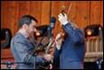 A person playing violin and a person holding a microphone

Description automatically generated