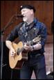 A person playing guitar and singing

Description automatically generated