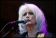 A person with white hair and a microphone

Description automatically generated