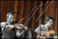 A group of men playing instruments

Description automatically generated