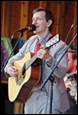 A person playing guitar and singing

Description automatically generated
