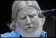 A person with a beard and a microphone

Description automatically generated