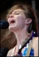 A person singing into a microphone

Description automatically generated