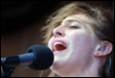 A person singing into a microphone

Description automatically generated