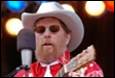 A person in a cowboy hat and sunglasses

Description automatically generated