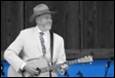A person in a hat playing a guitar

Description automatically generated
