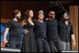 A group of people standing on a stage

Description automatically generated