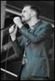 A person singing into a microphone

Description automatically generated