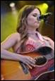 A person playing guitar on stage

Description automatically generated