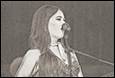 A person singing into a microphone

Description automatically generated