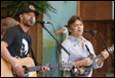 A group of men playing guitars and singing

Description automatically generated