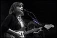 A person singing into a microphone with a guitar

Description automatically generated