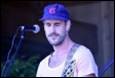 A person with a hat and guitar

Description automatically generated