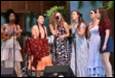 A group of women singing on stage

Description automatically generated