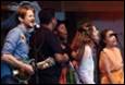 A group of people singing on stage

Description automatically generated