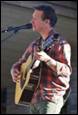 A person playing guitar and singing

Description automatically generated