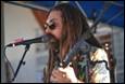 A person with long hair and beard singing into a microphone

Description automatically generated