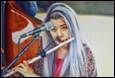 A person with long hair playing a flute

Description automatically generated