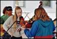 A group of people playing violin

Description automatically generated
