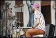 A person sitting on a drum set

Description automatically generated
