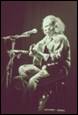 A person sitting in a wheelchair playing guitar

Description automatically generated