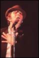 A person in a hat speaking into a microphone

Description automatically generated with medium confidence