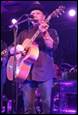 A person playing a guitar on a stage

Description automatically generated with medium confidence